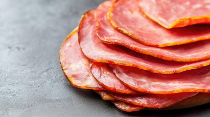 Sliced cured meat on a dark surface, ready for serving or garnishing dishes.