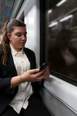 Young Businesswoman in a Suit Working on Smartphone During Nighttime Train Journey