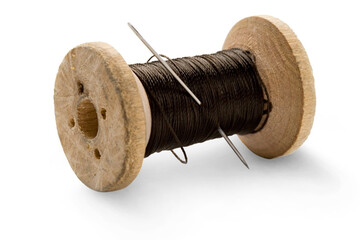 Thread bobbin and needle on white background