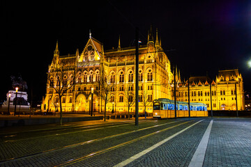 Fototapeta premium Hungarian Parliament and riding tram along Lajos Kossuth sqaure at night, Budapest