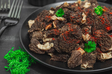 Raw black morel mushrooms with fresh parsley. Vegan ingredient for cooking healthy food