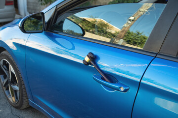 Judge gavel on a blue car.