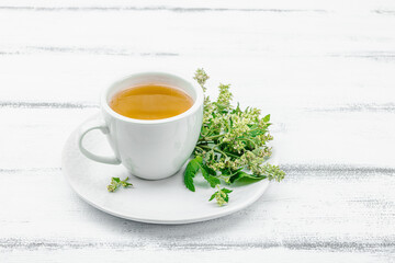 Lemon balm tea on white wooden background. Fresh edible herbs, trendy drink. Organic healthcare
