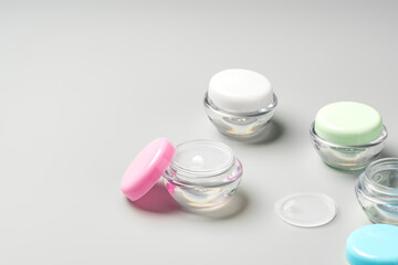 Colorful cosmetic containers arranged neatly on a light gray background