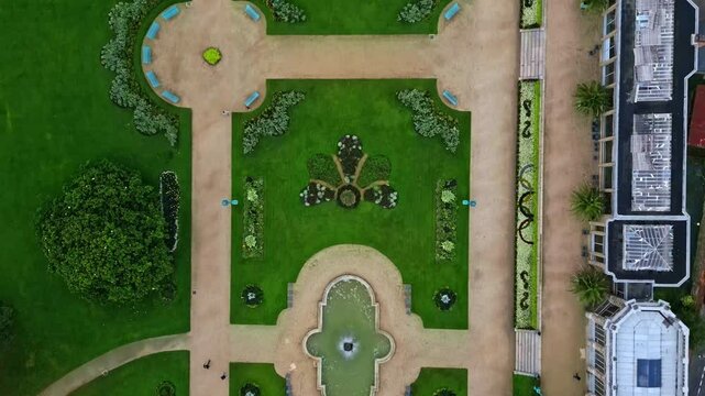 Drone flying over Thabor gardens with fountains and flower beds, Rennes in France. Aerial drone top-down forward