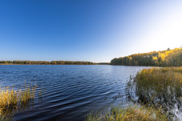 A calm lake with a blue sky in the background