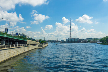 Fototapeta premium A city with a river running through it and a tall tower in the background