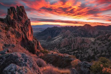 Fototapeta premium A dramatic image of rugged desert mountains under a fiery sunset sky, with deep hues of red and orange painting a spectacular scene, embodying passion and raw beauty.