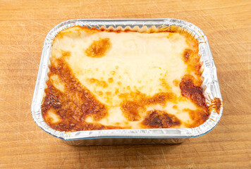 Lasagna portion in aluminium foil tray isolated. Oven baked lasagne for heating, container, airplane food