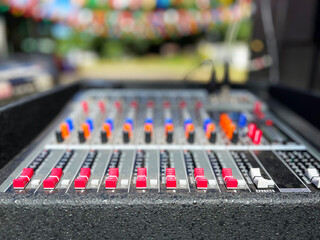 audio mixer soundboard. The mixing console features several rows of brightly colored knobs and...
