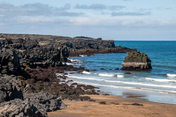 Skardsvík beach Iceland, view of a golden sandy beach with black basalt rock formations