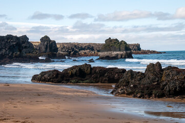 Skardsvík beach Iceland, view of a golden sandy beach with black basalt rock formations