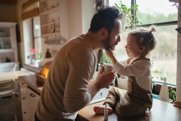 Sick girl with fever and cold at home. Father taking care of daughter.