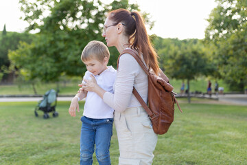 A woman and a child are walking in a park