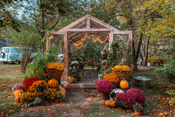 Charming gazebo with autumn flowers and pumpkins in a cozy garden