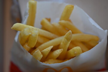 close-up fries in a white bag, French fries, unhealthy junk food. 