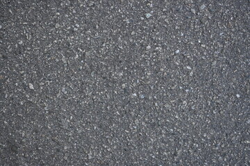 cracks on grey asphalt, repair of old road surface as background, wet pavement texture, gray asphalt texture with red and white gravels	
