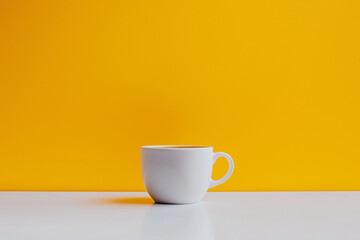 Obraz premium White Coffee Cup on Yellow Background