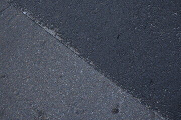 Fototapeta premium dark grey and light grey asphalt, junction of new and old road surfaces, repaired roadway
