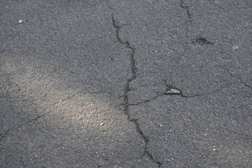 Cracks on grey asphalt close-up, old cracked asphalt close-up, old road surface bitumen  
