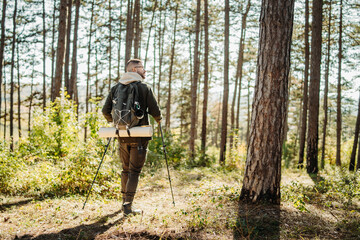 Young caucasian man hiking or trekking through the forest 