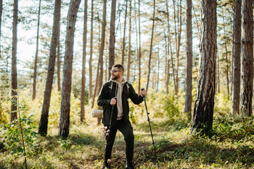 Young caucasian man hiking or trekking through the forest 
