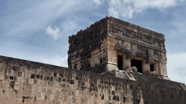 Handheld close-up panning shot of the Temple of the Jaguars atop the Great Ball Court at Chichen Itza in Yucatan, Mexico. 4K