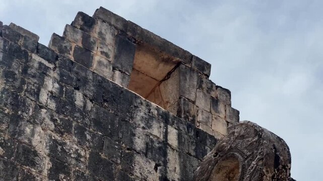 Handheld close-up tilting up shot of the stone ring above the Great Mayan Ball Court at Chichen Itza in Yucatan, Mexico. 4K