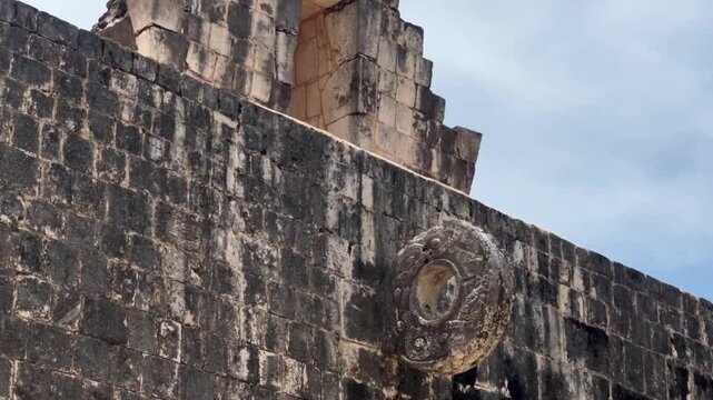 Handheld close-up panning shot of the stone ring at the Great Ball Court in Chichen Itza, Mexico. 4K