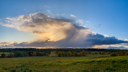 Fototapeta premium A serene rural landscape at sunset with dramatic cloud formations, evoking tranquility and natural beauty, perfect for Earth Day themes