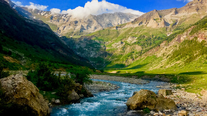 A serene mountain stream winds through lush green valleys, embodying tranquility and nature escape, ideal for promoting Earth Day awareness