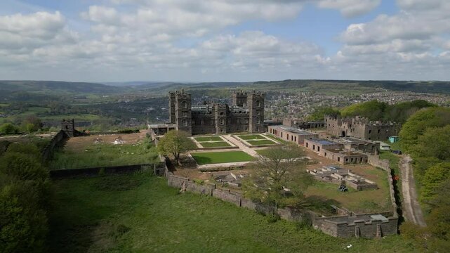 Drone shot around Riber castle at Matlock, Derbyshire with green landscape and cloudy sky