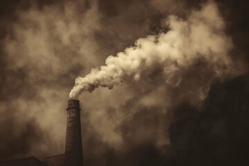 Industrial Revolution. Dark Sepia Toned Image of Pollution from Industrial Chimney
