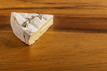 fresh delicious brie cheese on a wooden surface close up shallow depth of field