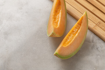 sliced sweet melon on a marble surface close up