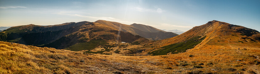 Panoramic view of Mount Hoverla with a golden autumn trekking path, showcasing the scenic beauty of the Carpathian Mountains. Perfect for travel promotions, hiking blogs, and nature enthusiasts.