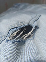 Jeans torn denim texture. Old blue jeans torn denim texture