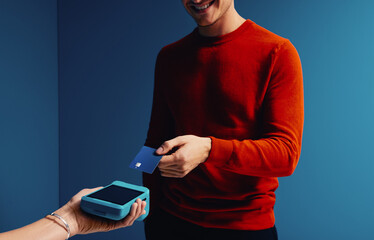 Happy shopper making a card payment to a merchant with a card reader