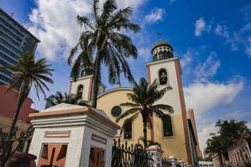 Historic church in Luanda Angola surrounded by palm trees under a bright sky