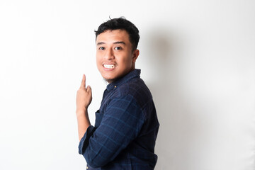 Side view of Adult Asian man smiling to the camera while pointing his behind