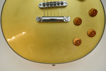 Close-up photograph of a vintage gold-plated electric guitar, details