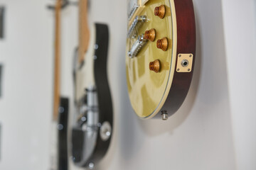 vintage golden electric guitar hanging on a wall, side shot with blurring_