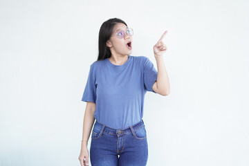 Beautiful Asian woman looks shocked, with a 'wow' expression, pointing to the side with her forefinger