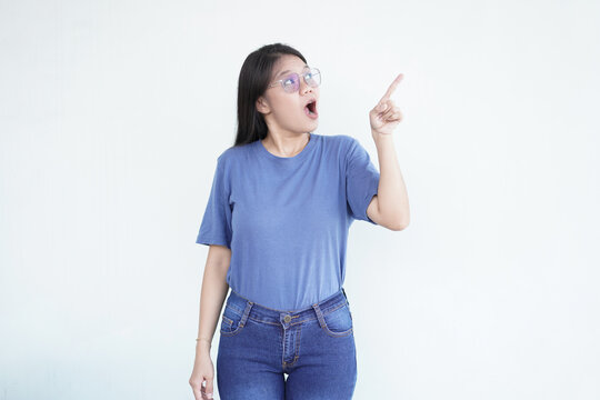 Beautiful Asian woman looks shocked, with a 'wow' expression, pointing to the side with her forefinger