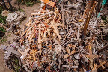 A large collection of wooden crosses, crucifixes, and rosaries displayed at Kryžių Kalnas (Hill of Crosses), symbolizing faith, devotion, and pilgrimage.