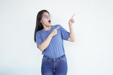 Beautiful Asian woman looks shocked, with a 'wow' expression, pointing to the side with her...