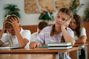 Fototapeta premium Sitting by the desks. Pupils, kids in the classroom together