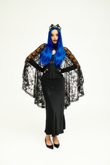 A young woman with vibrant blue hair showcases her unique Halloween costume, exuding elegance.