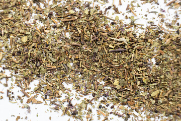 Dry basil spice seasoning macro texture on white background.