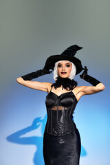 A beautiful woman showcases her Halloween spirit, wearing a striking witch costume and hat.